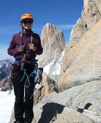 Marina Lencina wearing an orange helmet above snowy terrain in Torres del Paine.