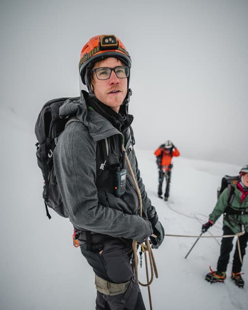 Martín Contreras Ried guiding a roped team on a glacier.